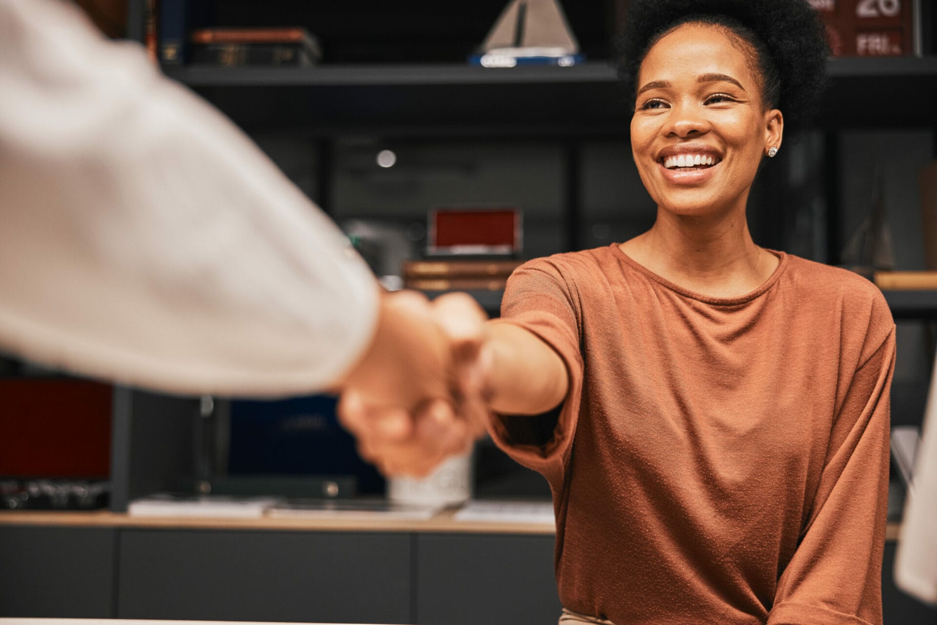 A trainer greeting a participant with a handshake